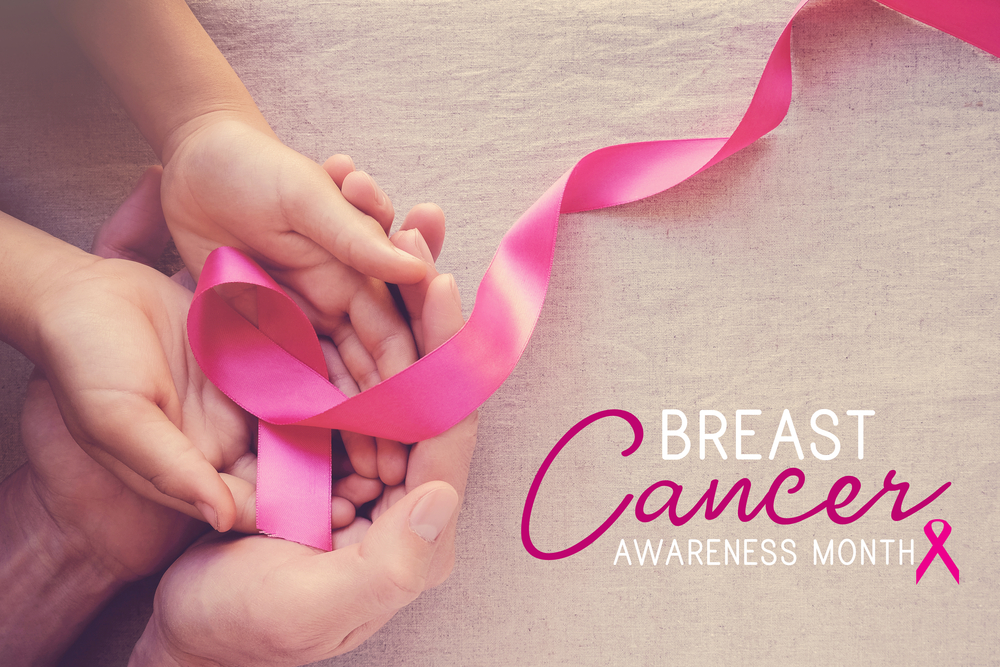 Hands holding pink cancer awareness ribbon